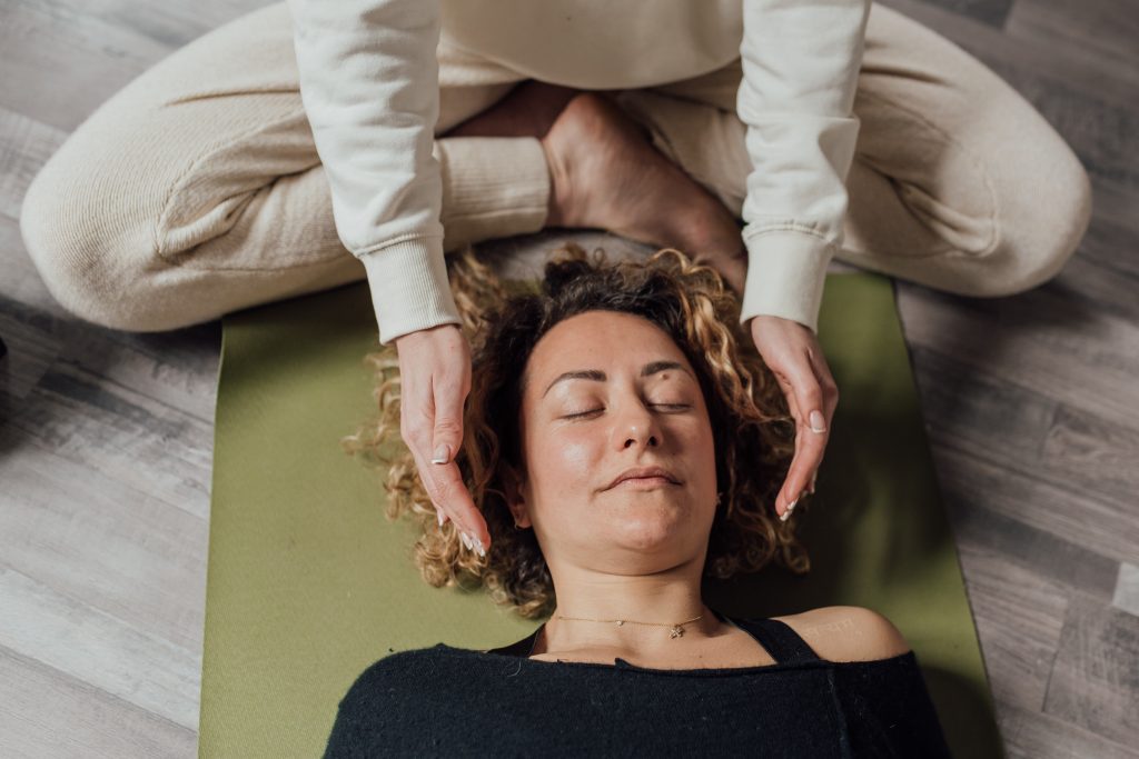 Therapist treating a woman lying on a mat