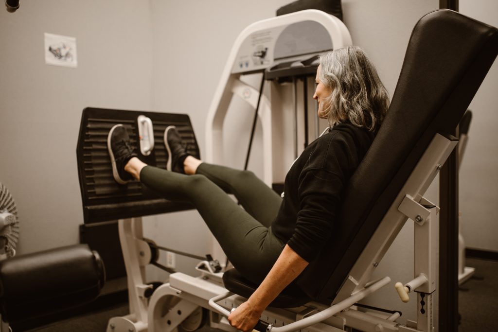 Woman exercising on a gym machine during rehab