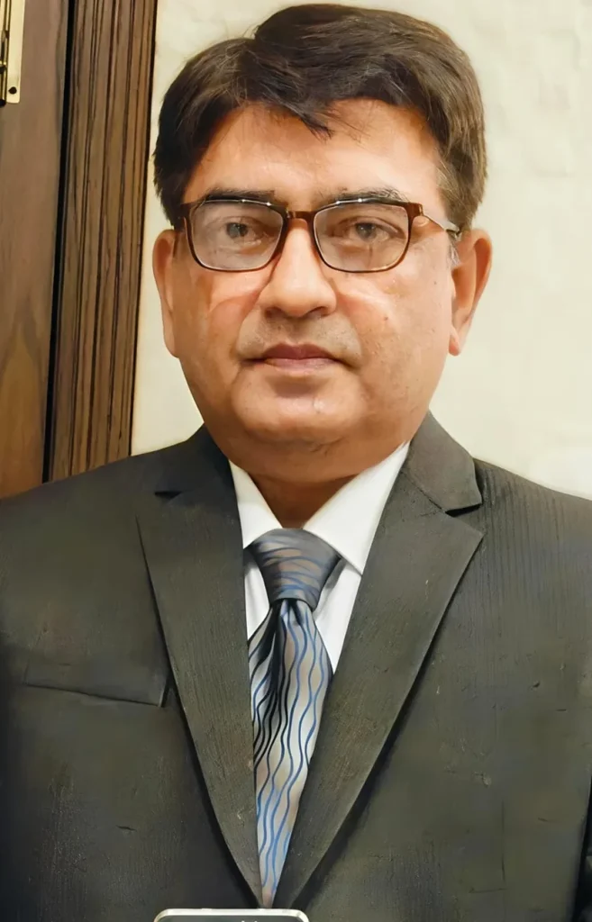 Dr. Khurram Bashir, gynaecologist and obstetrician at MD Health Center Lahore, wearing glasses, a dark suit and patterned blue tie