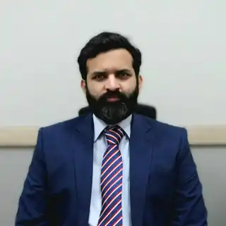 Dr. Muhammad Hashir Amin Malik, consultant clinical neurologist and stroke physician at MD Health Center Lahore, wearing a blue suit and striped tie